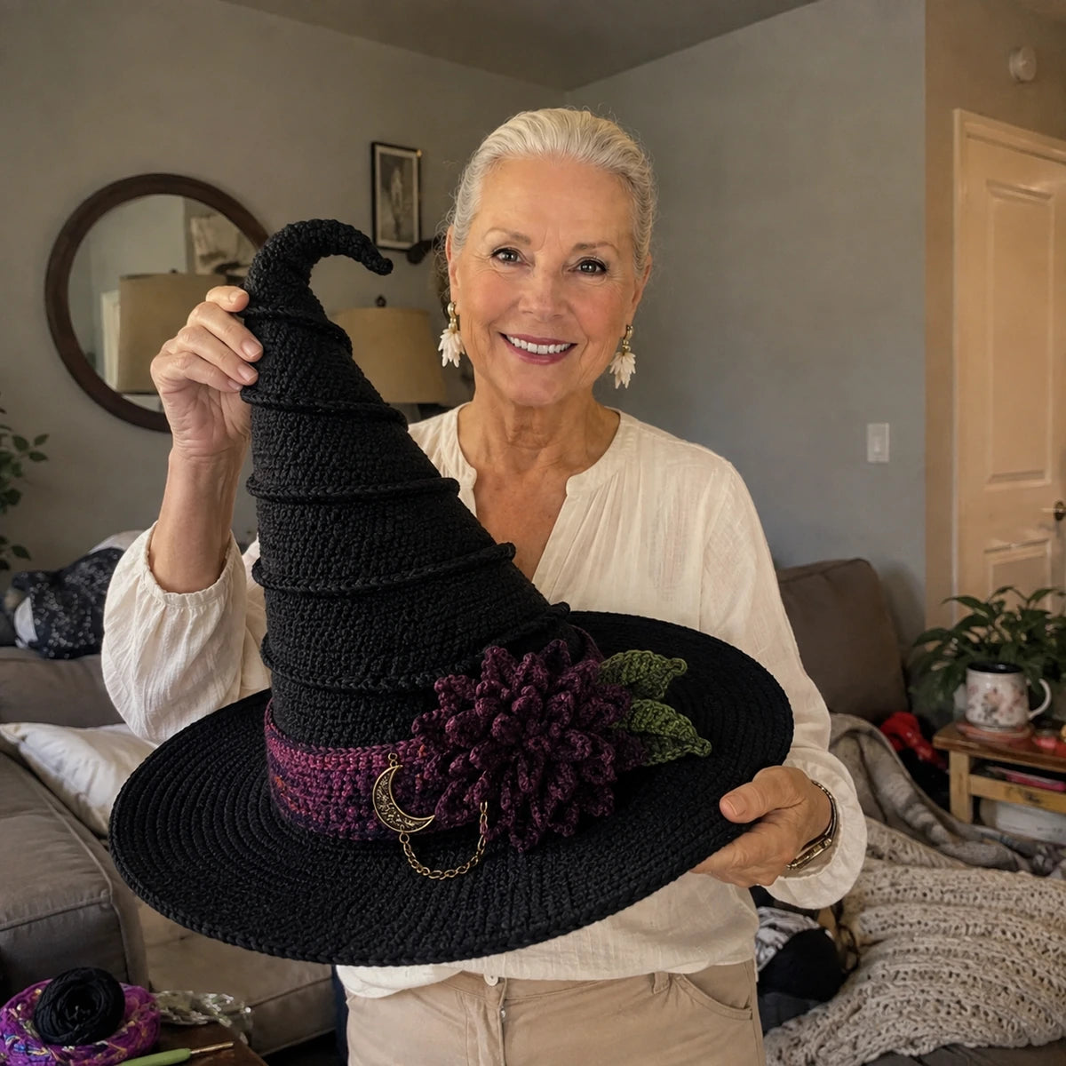 Maker holding a completed Nocturne Bloom style crochet witch hat for scale