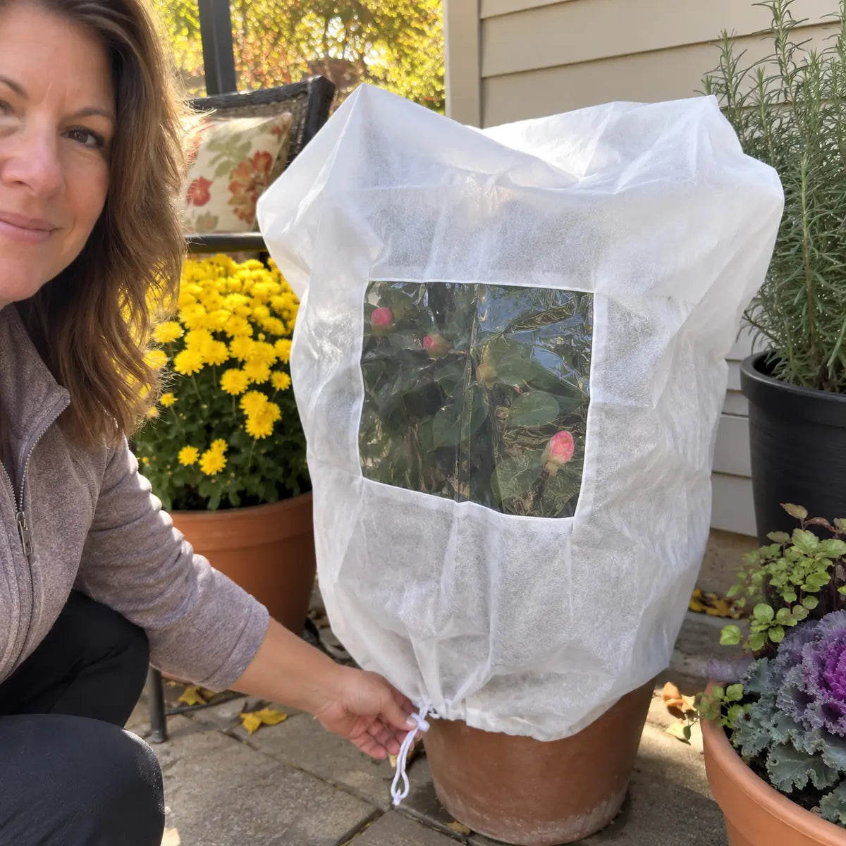 Customer beside a protected rose plant on her patio