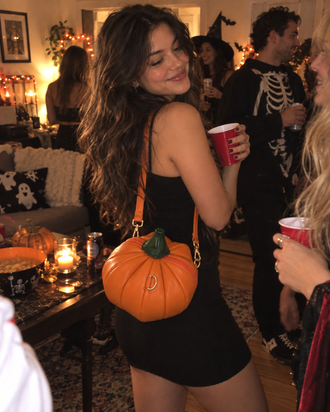 Woman carrying pumpkin purse at a Halloween party
