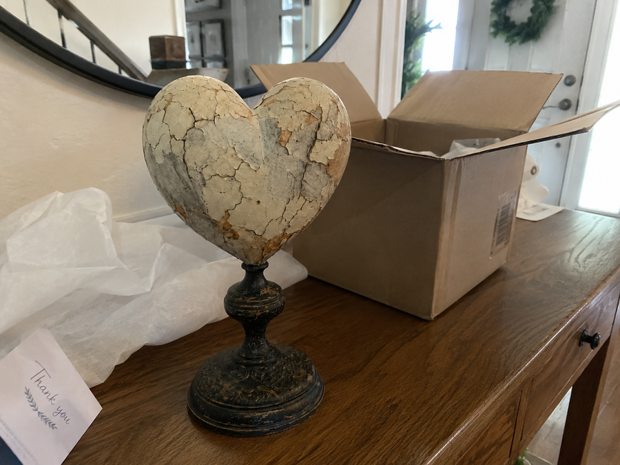 Unboxing scene with distressed vintage heart pedestal