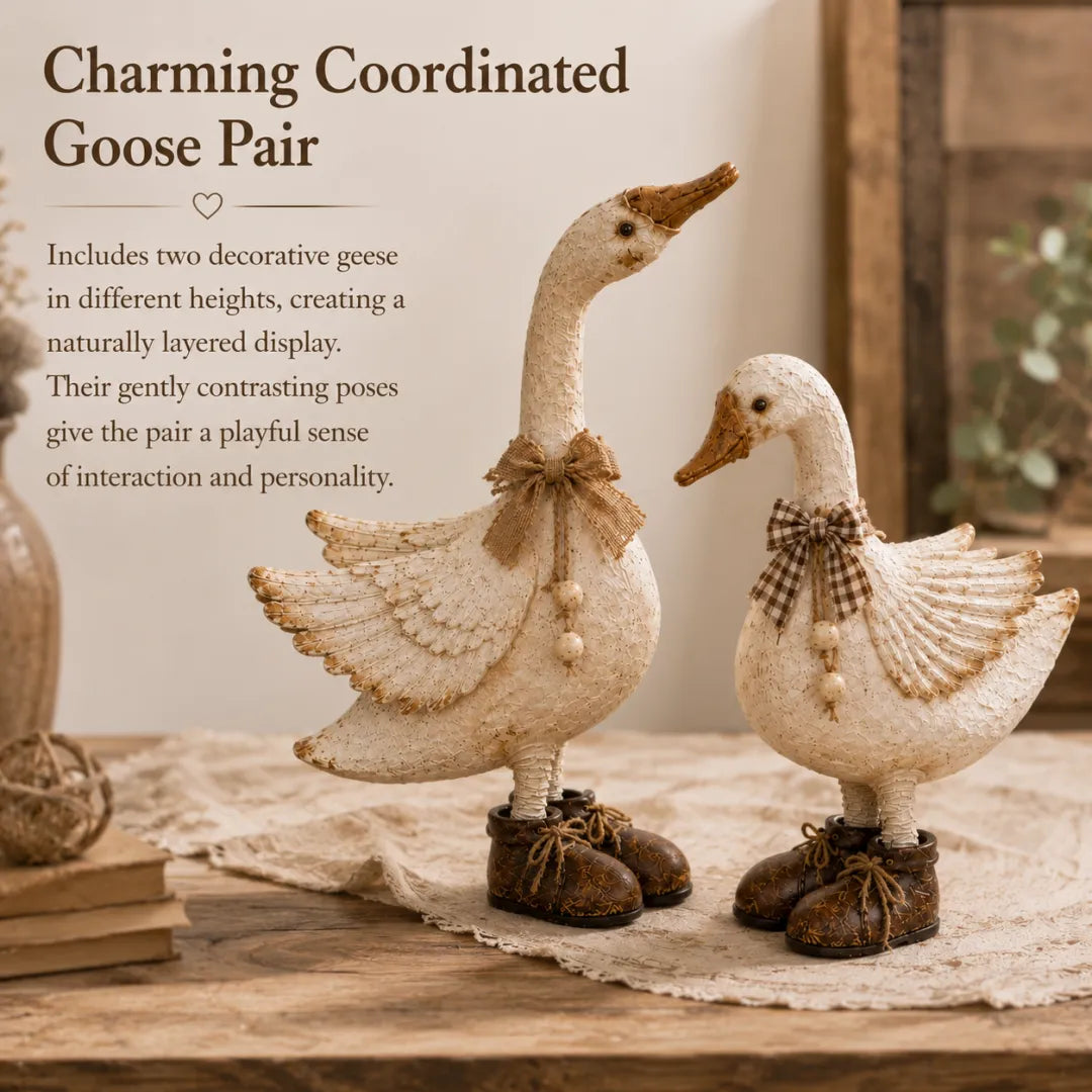 Coordinated cream cottage goose figurine pair wearing bows and boots