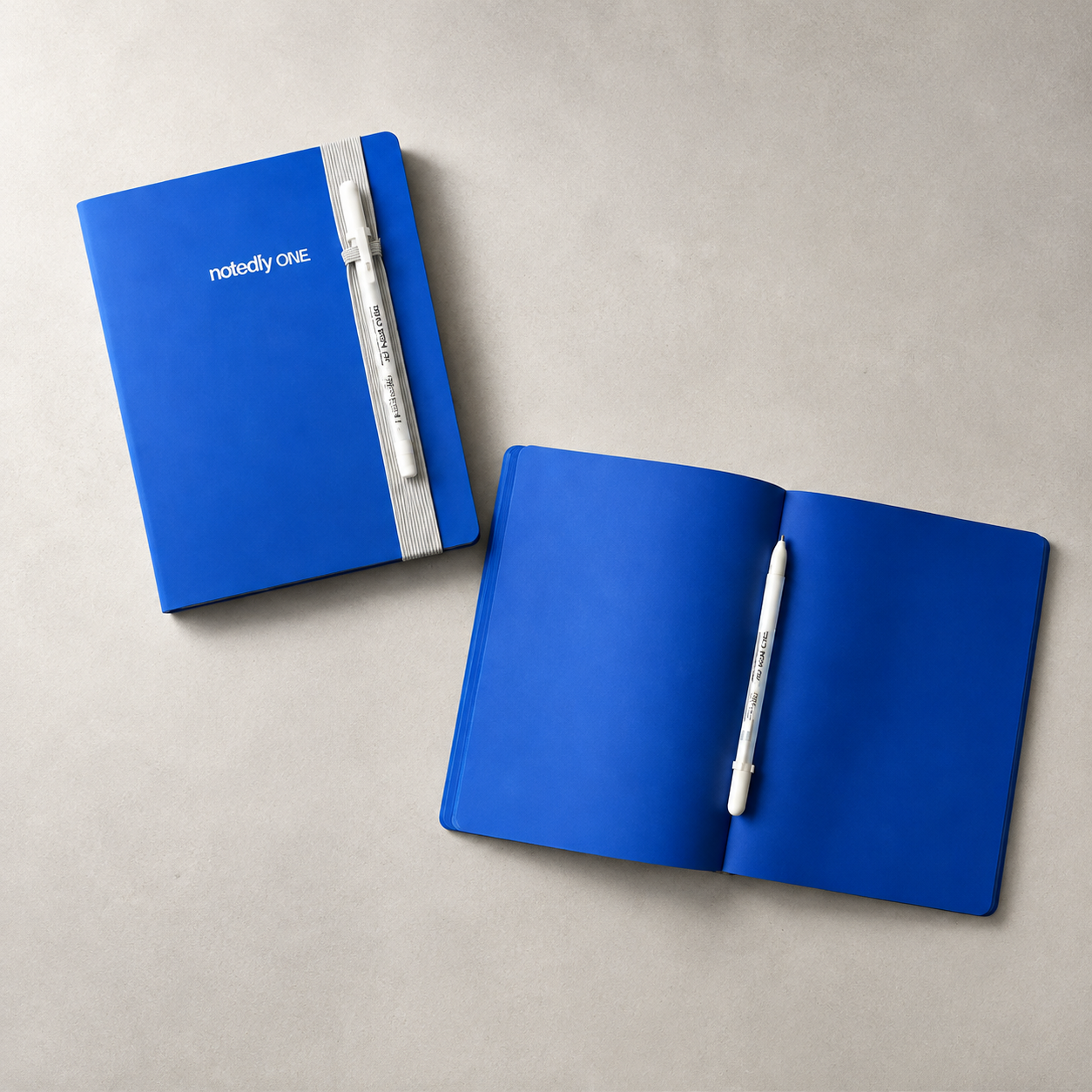 Closed and open blue-page notebook with white gel pen