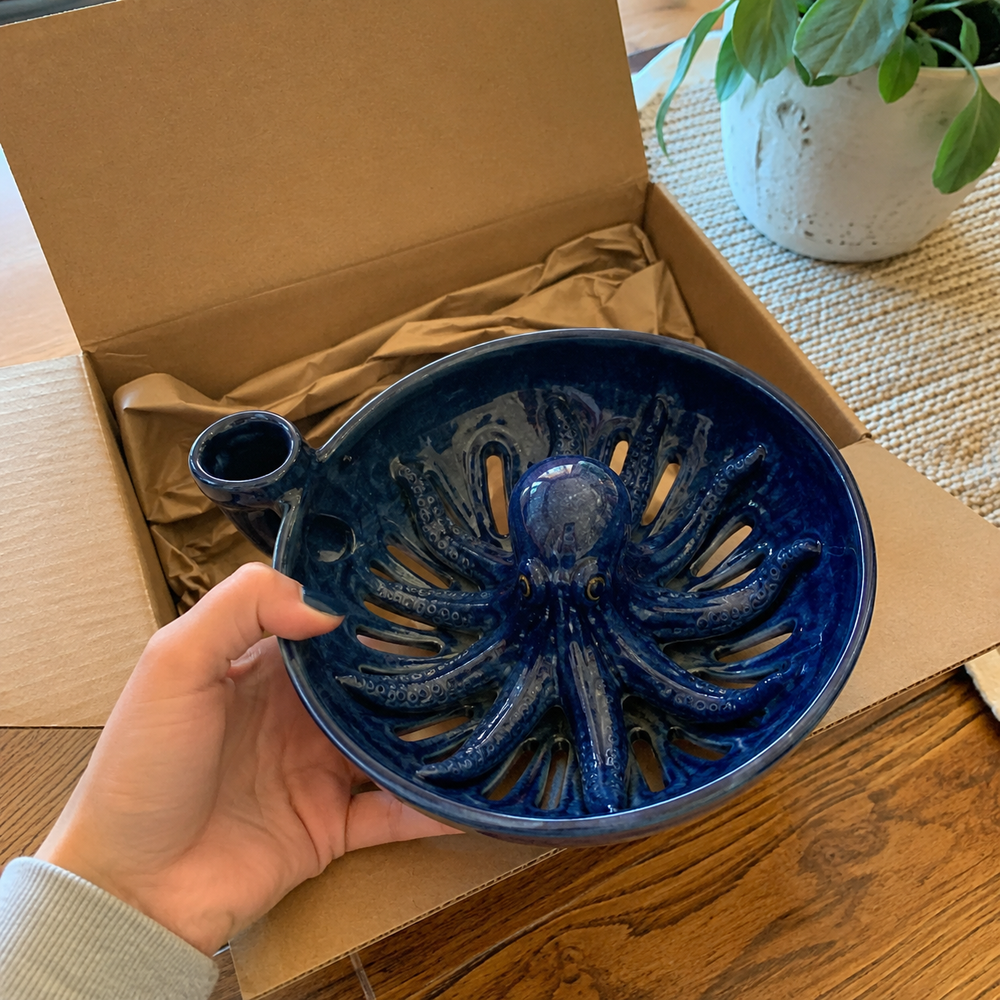 Hand holding octopus ceramic colander after unboxing