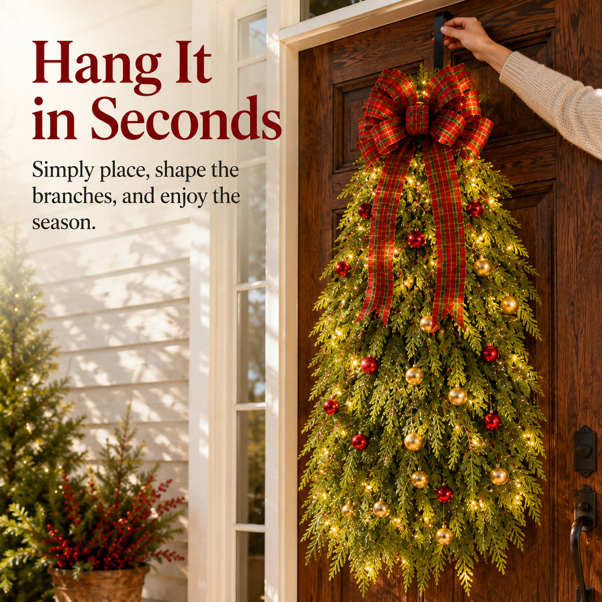 Person hanging the Christmas tree wreath on a front door