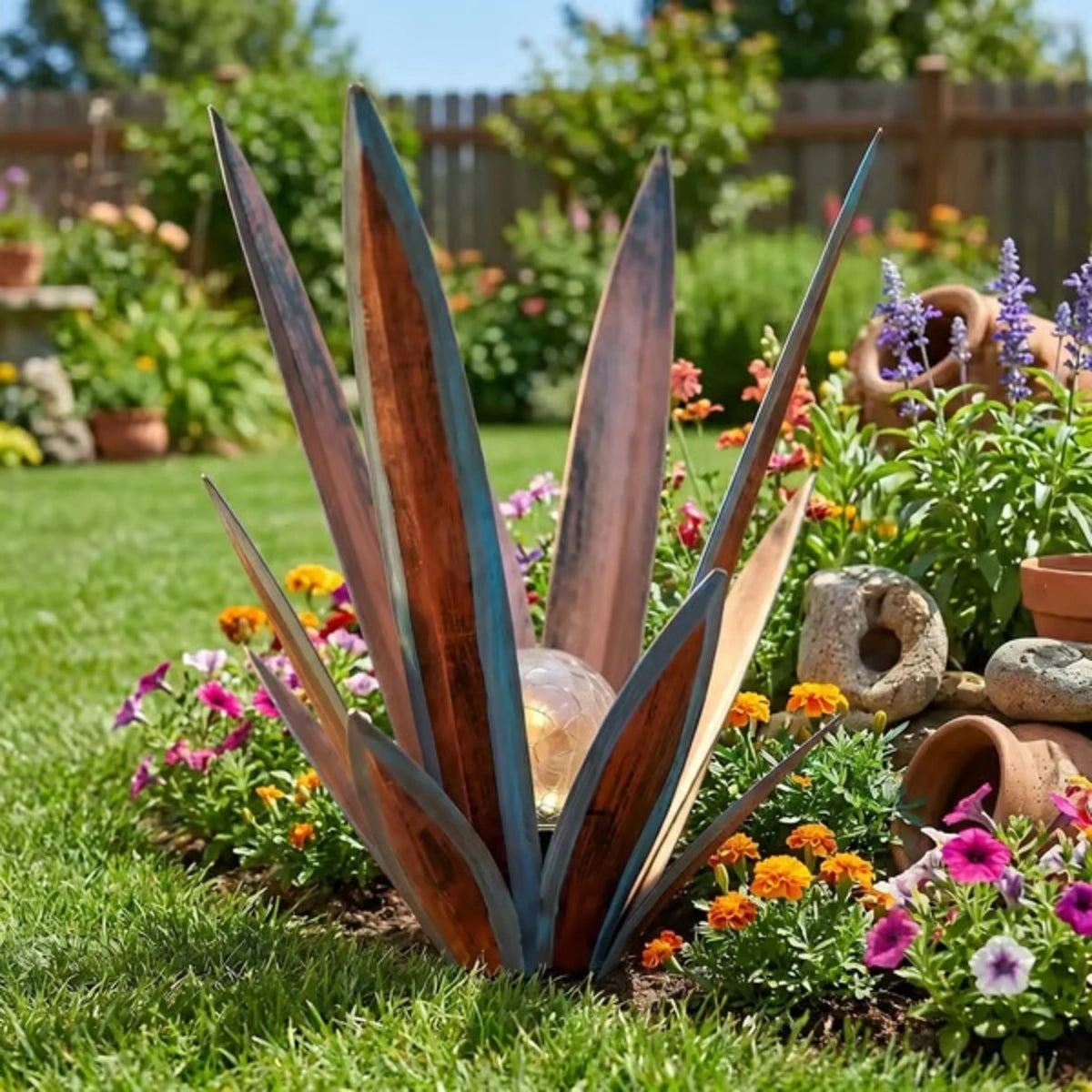 Customer-style daytime photo showing the agave light in a colorful garden bed