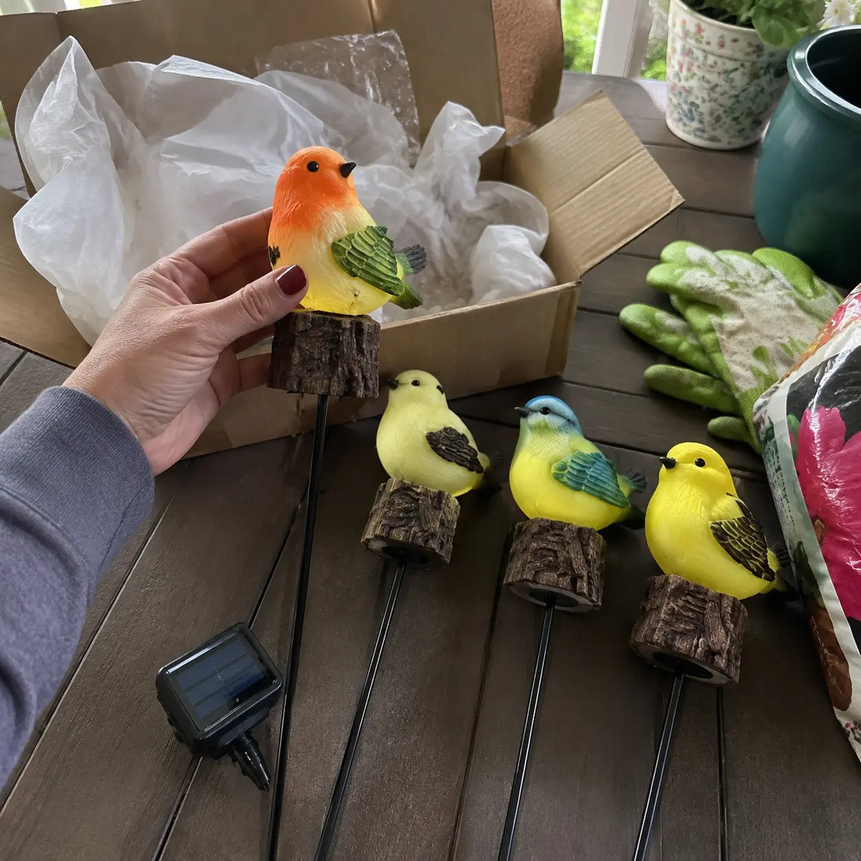 Customer unboxing the four bird stakes and their solar panel