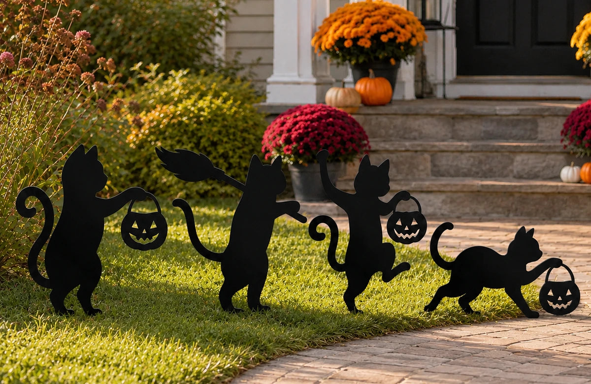 Set of four playful black cat metal garden stakes in a fall front yard