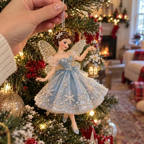 Hand hanging an icy-blue fairy Christmas ornament from a tree