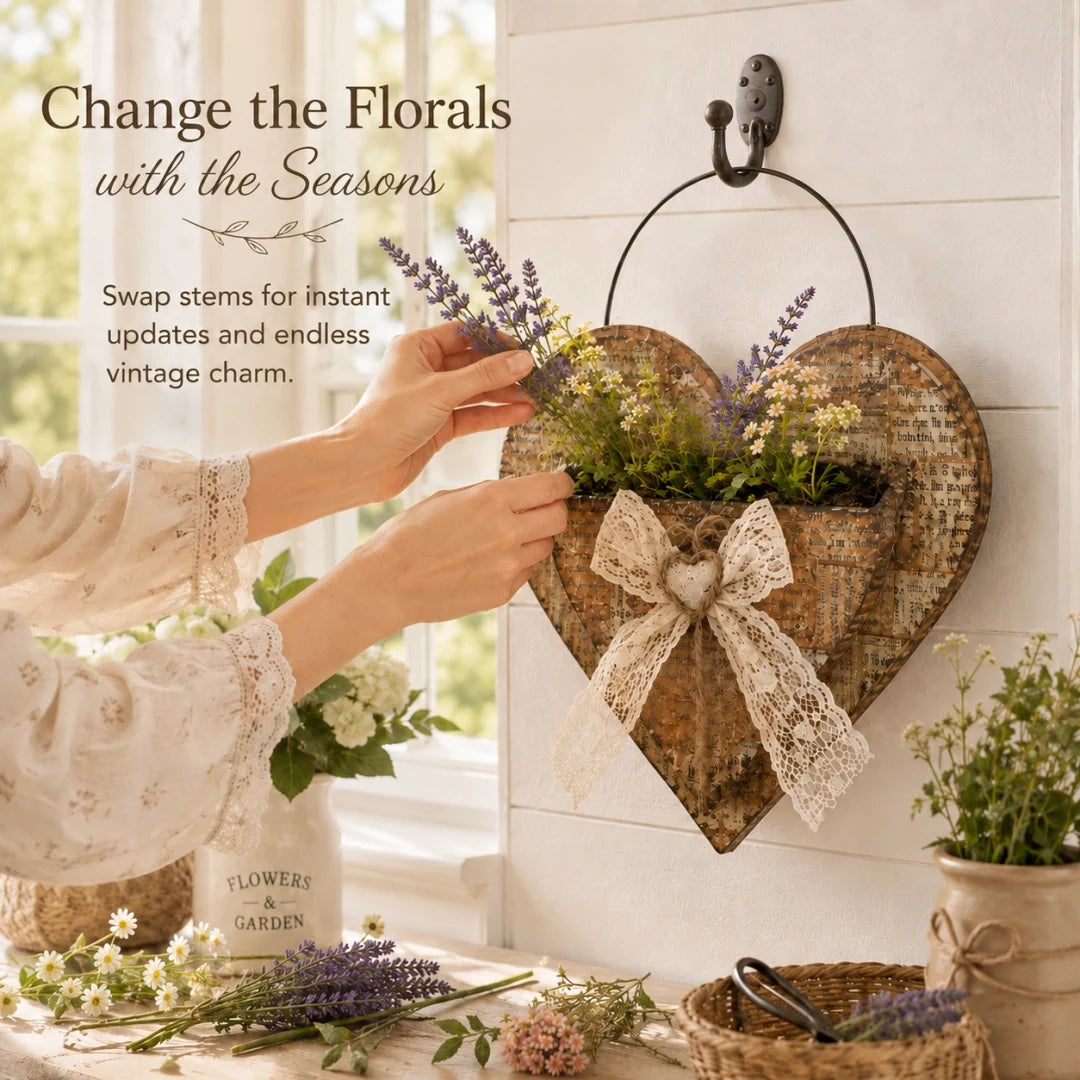 Hands changing seasonal flowers in the heart wall planter