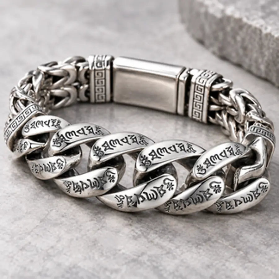 Silver-tone engraved bracelet arranged on natural stone