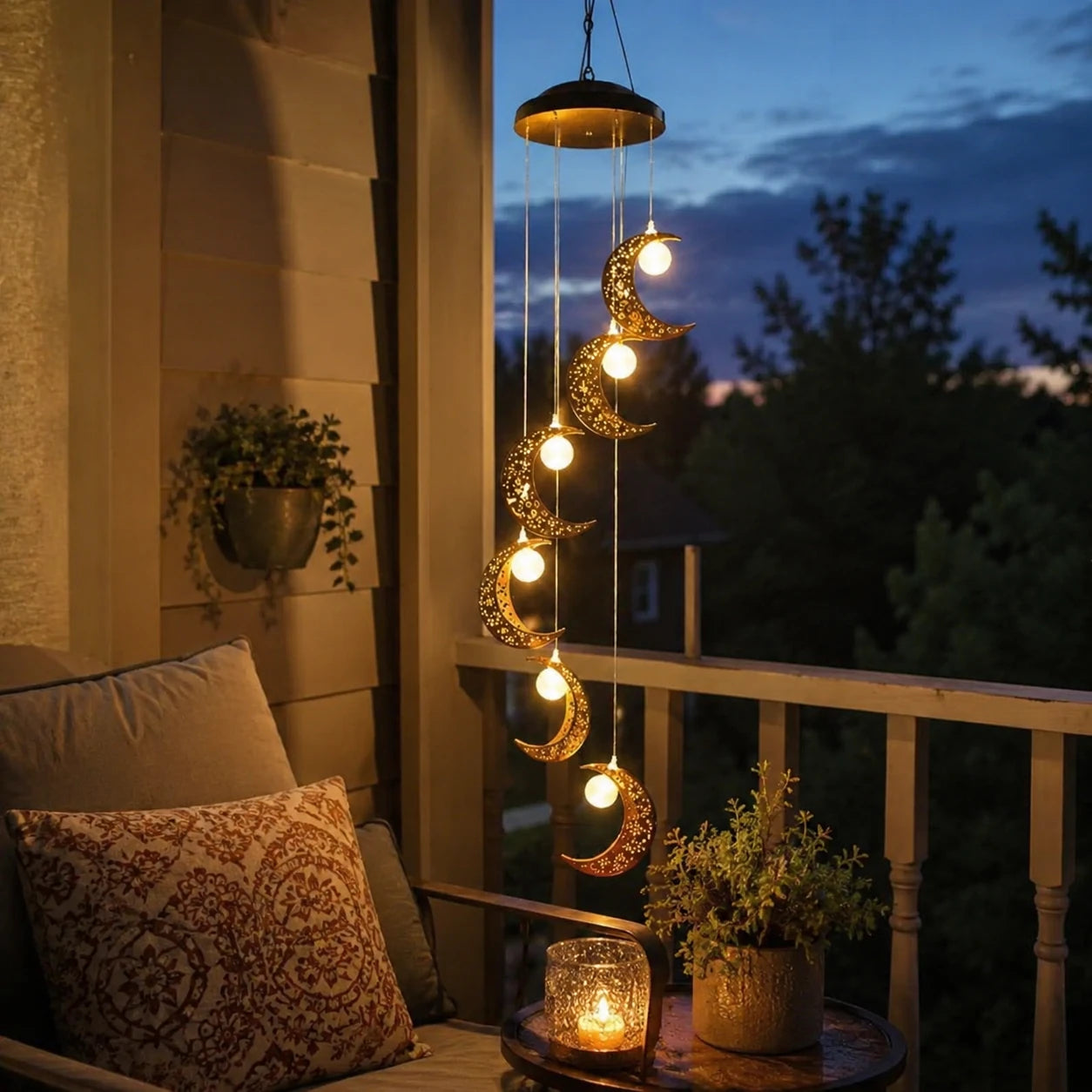 Customer photo of moon wind chime glowing at night on a porch