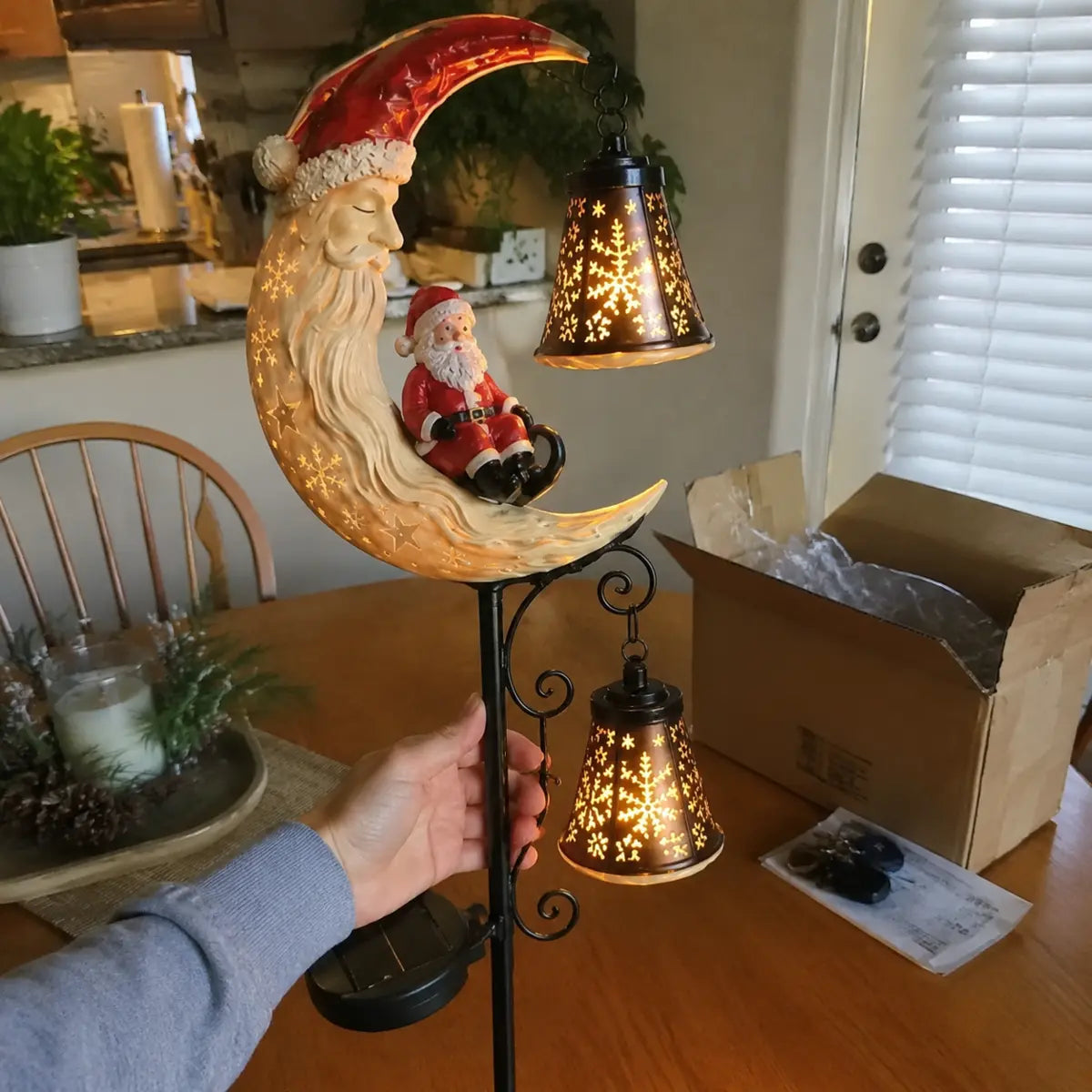 Customer holding the illuminated Santa Moonlight Lantern after unboxing