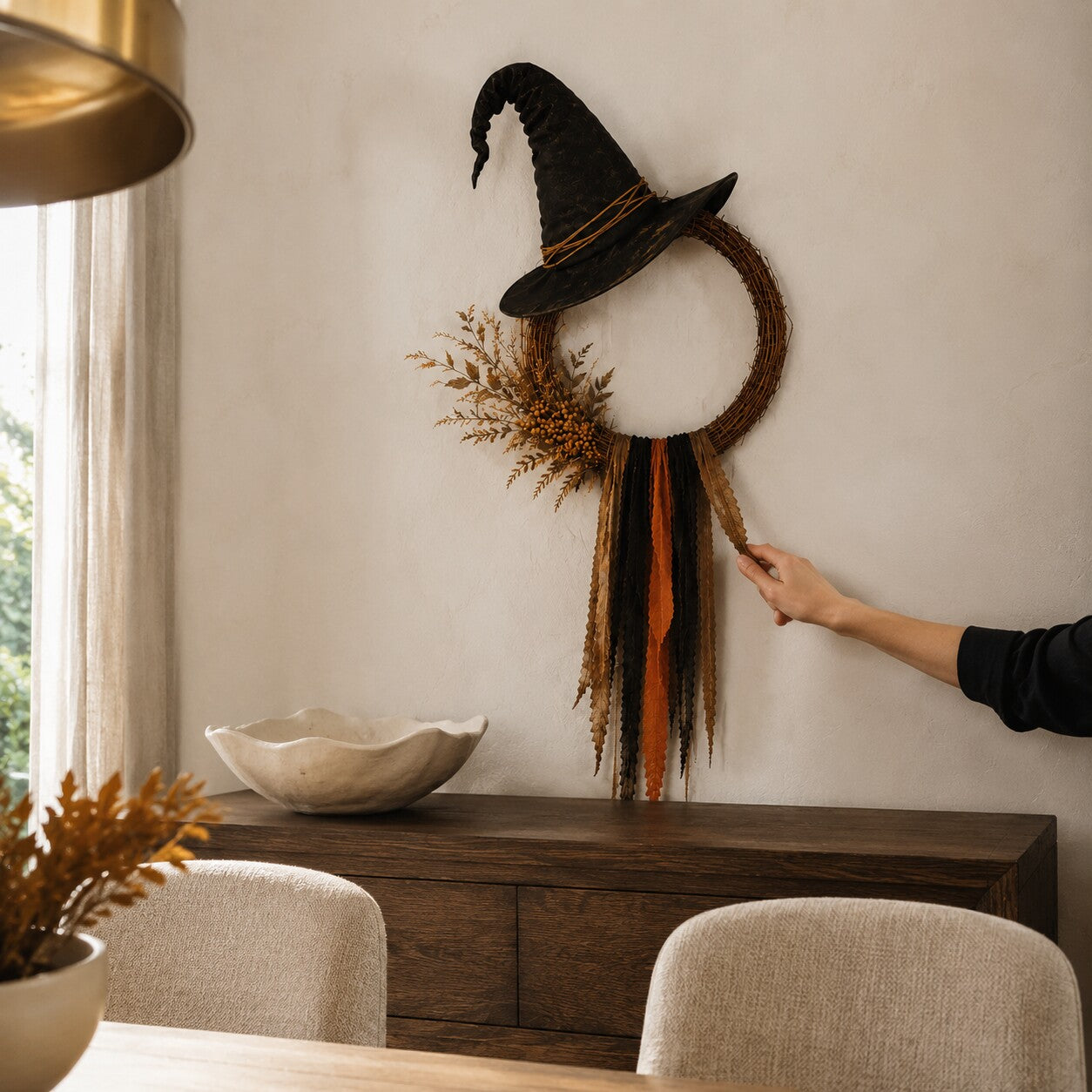 Customer arranging the long ribbons of the wreath above a dining room sideboard